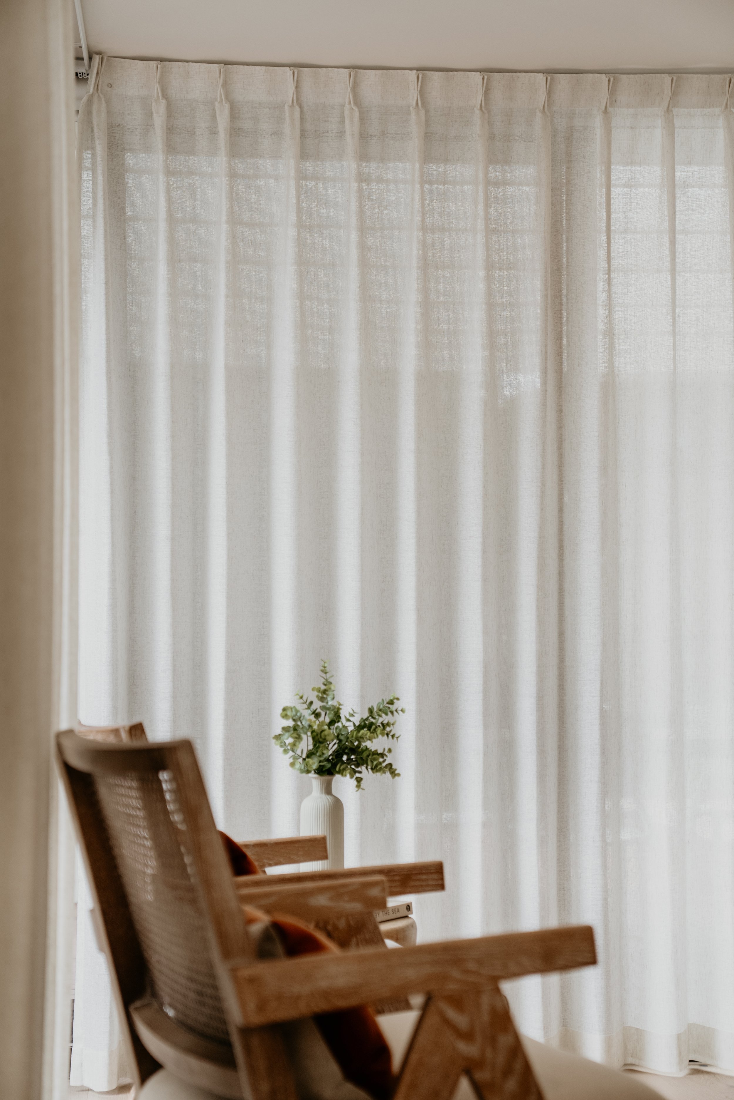 Floor to ceiling curtain in neutral interior